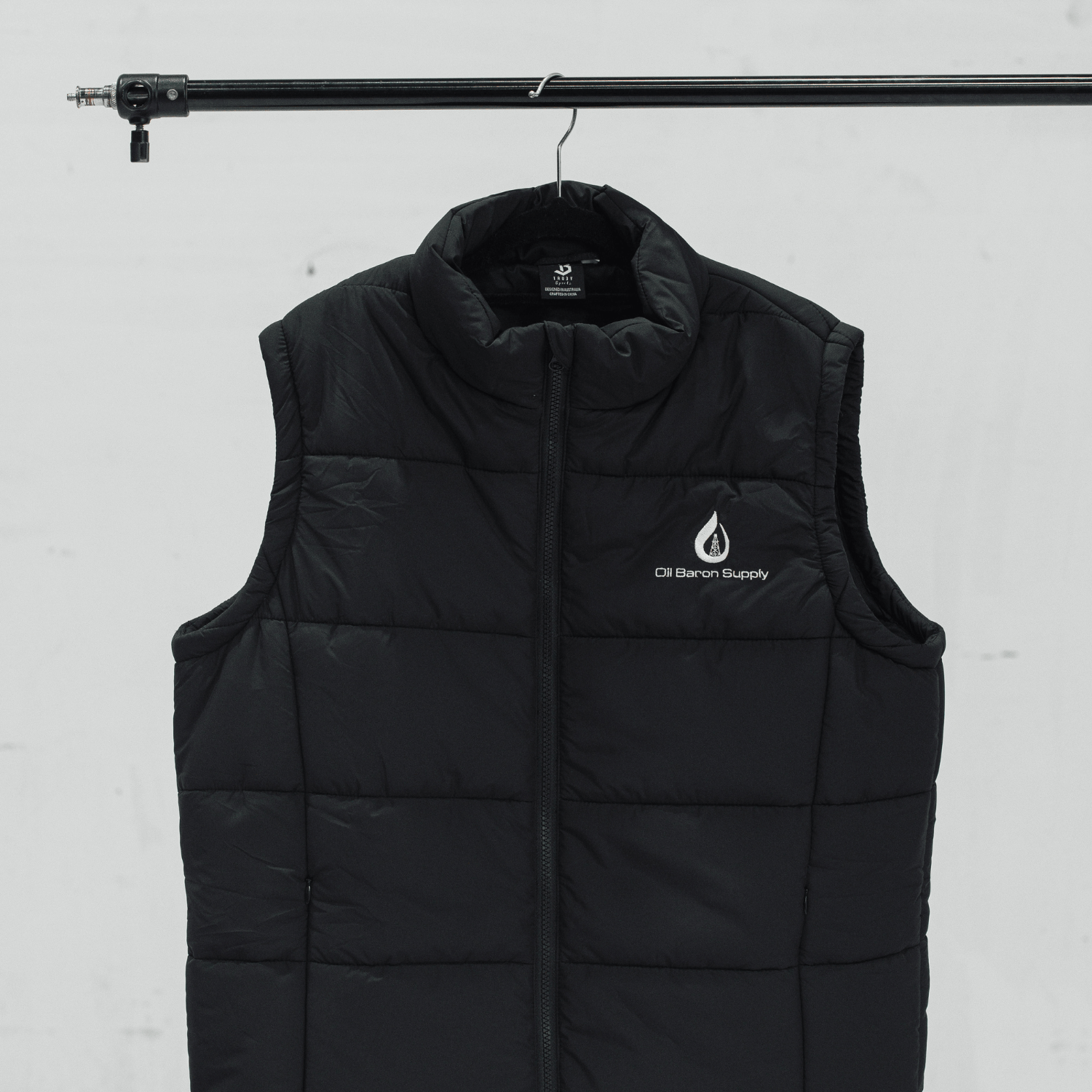 Black puffer vest with a logo on a white background