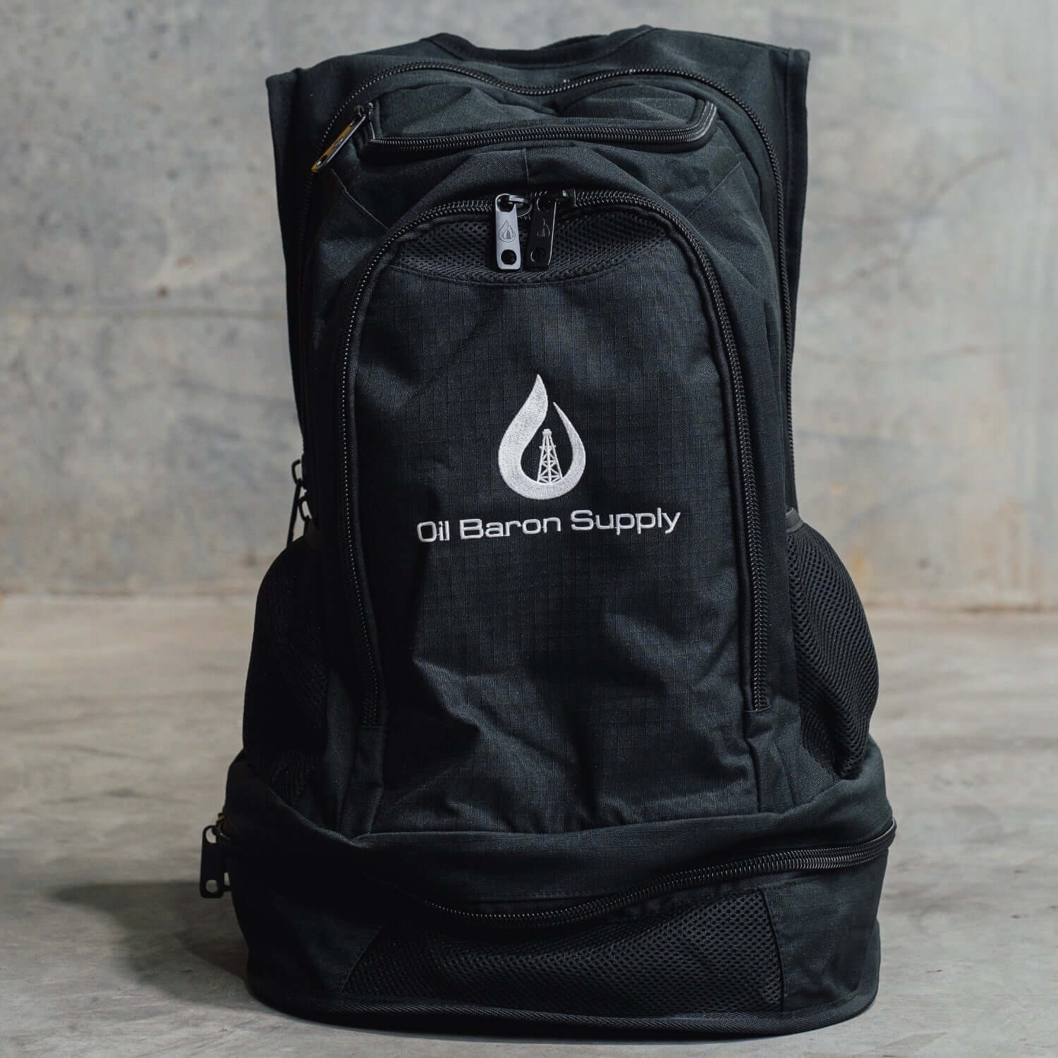 Black backpack with 'Oil Baron Supply' logo on a gray background