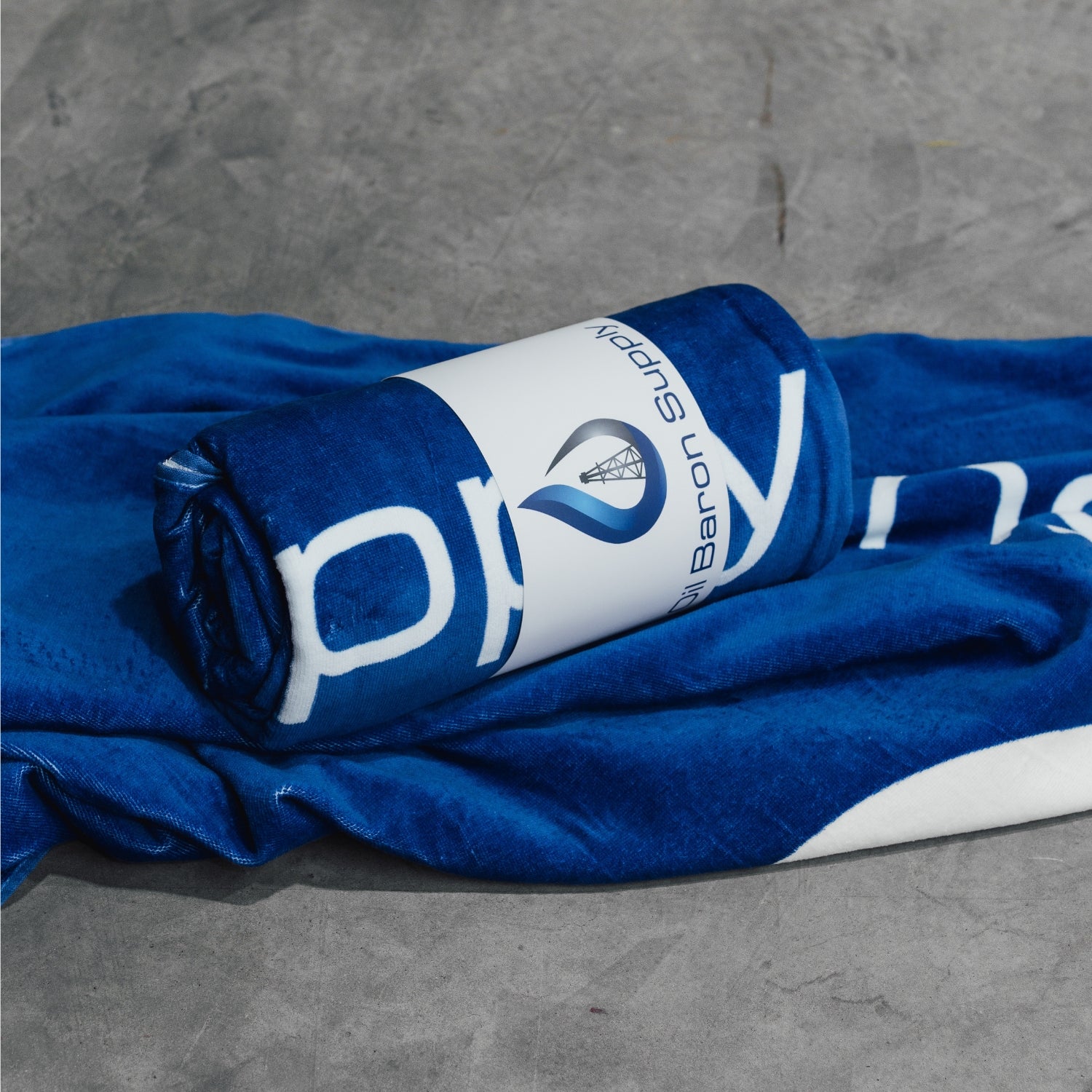 Blue towel with white branding on a gray surface