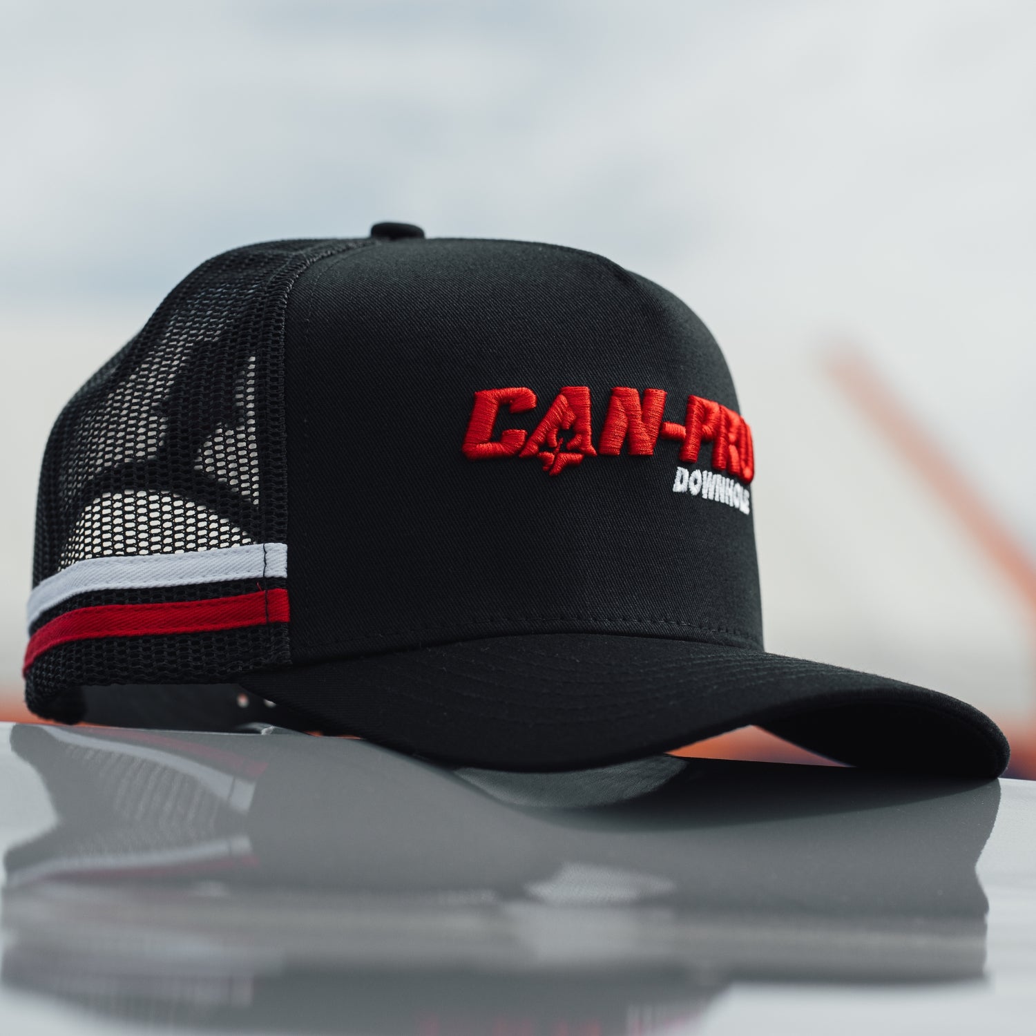 Black cap with red and white text on a reflective surface