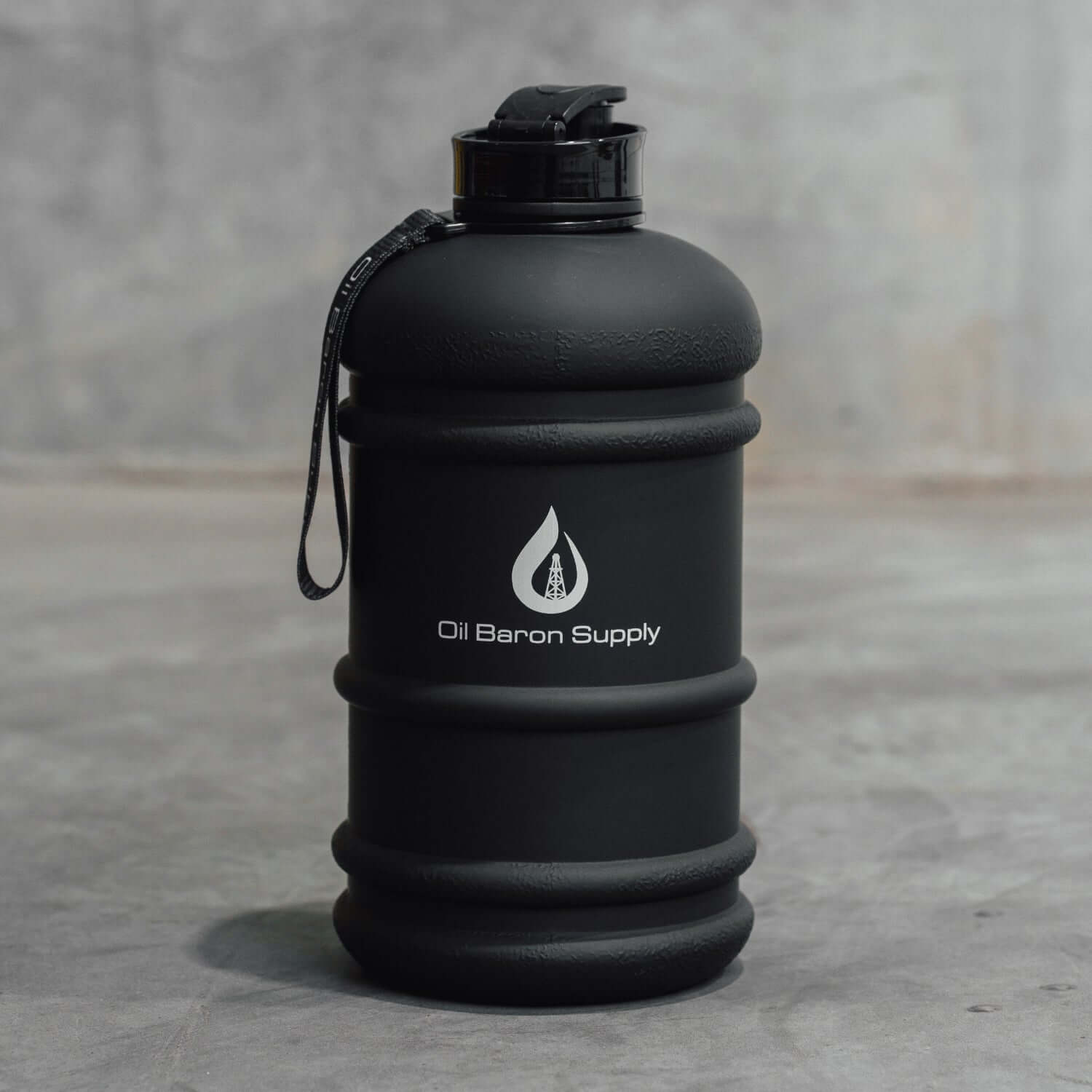 Black water bottle with 'Oil Baron Supply' logo on a gray surface