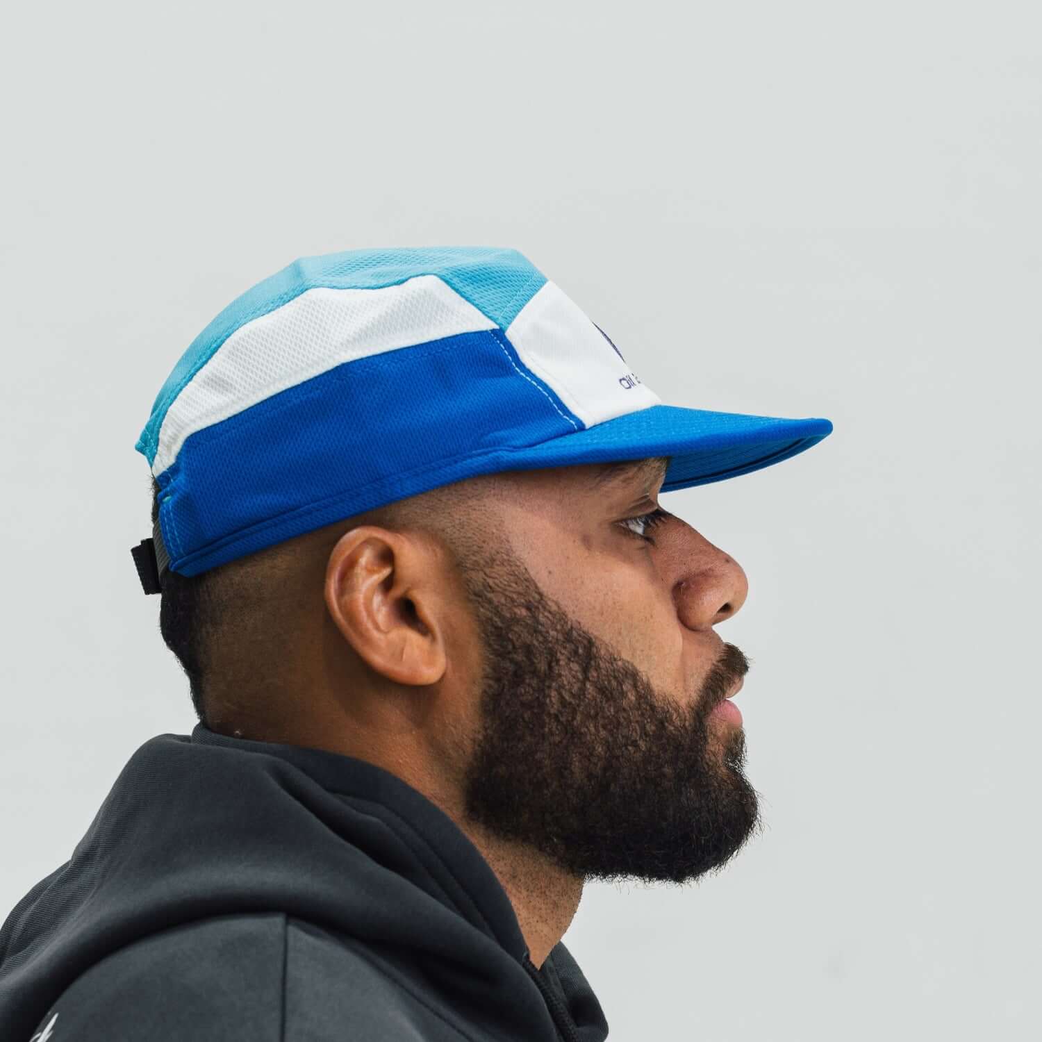 Person wearing a blue and white cap on a plain background